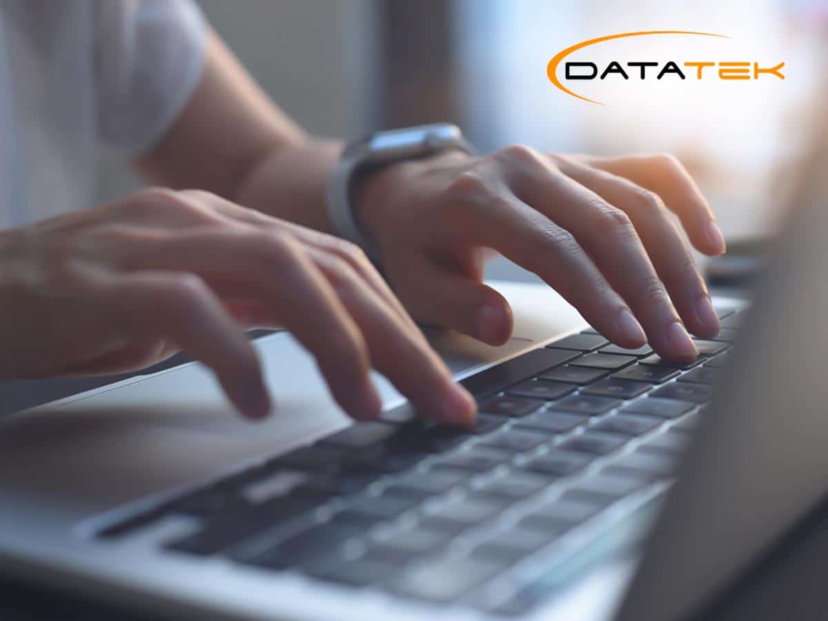 Close-up of hands typing on a laptop with the Datatek logo, emphasizing HIPAA compliance support