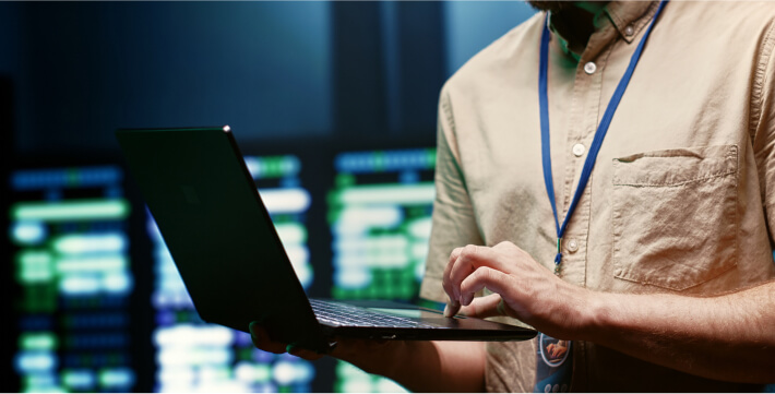 Technician monitoring cybersecurity systems on a laptop in a data center in AZ