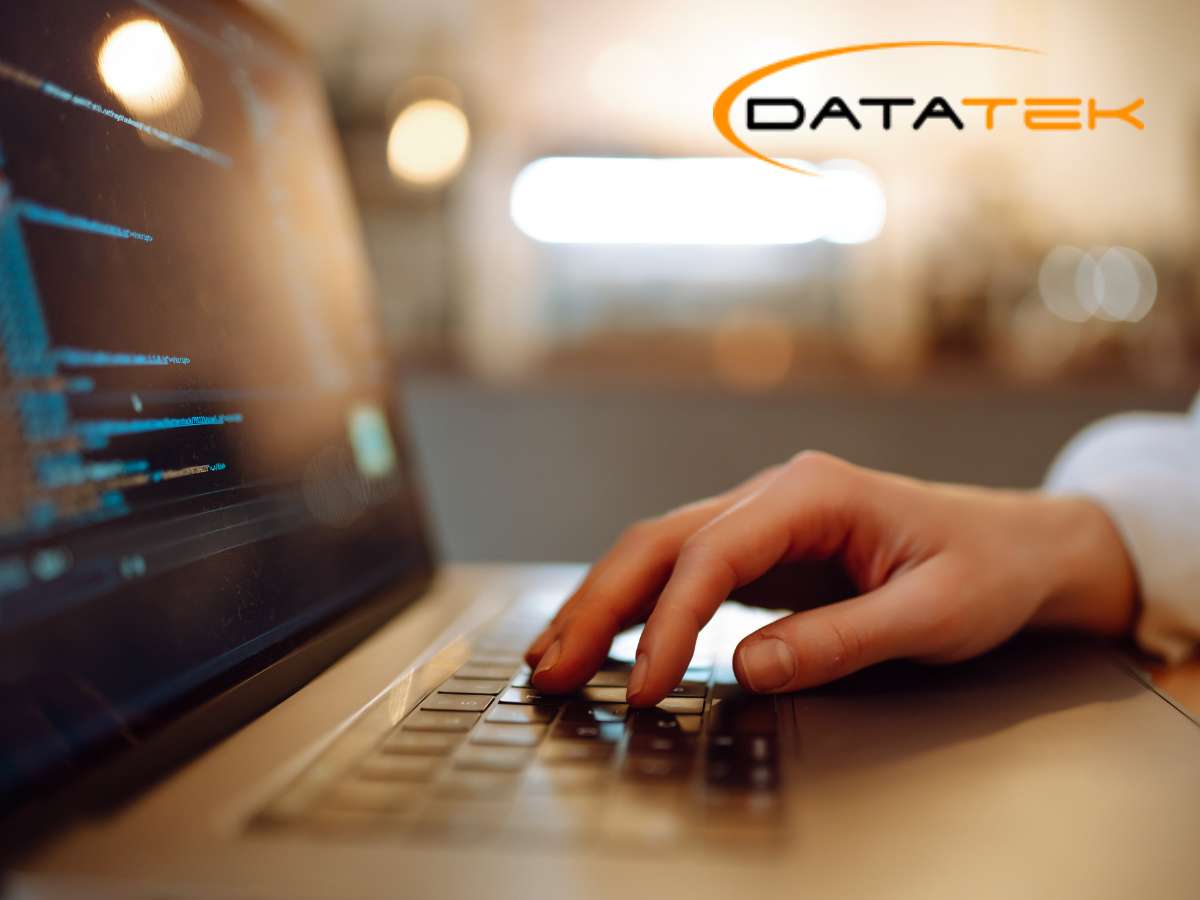 Person typing on laptop with code, representing Cybersecurity services by Datatek.